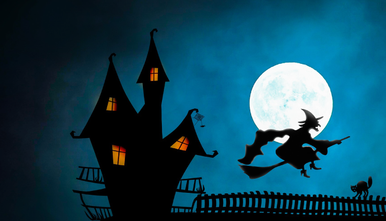 Witch flying in front of the moon next to a haunted house