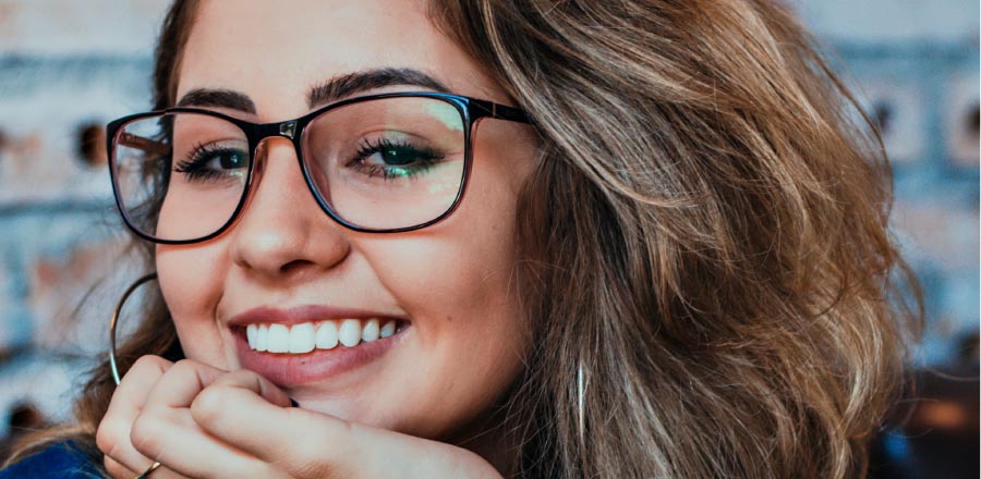 girl wearing glasses smiling with lingual braces